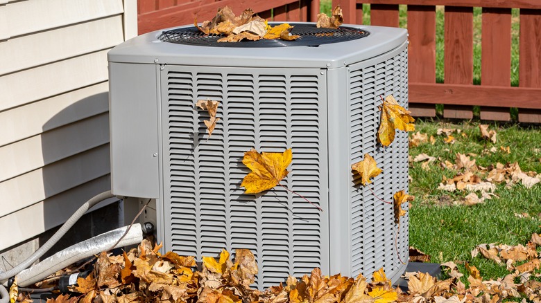 Air conditioner covered with leaves