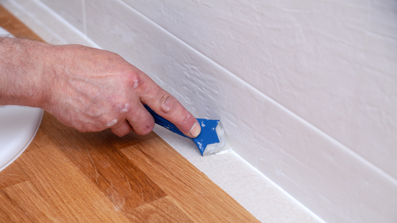 smoothing caulk with tool