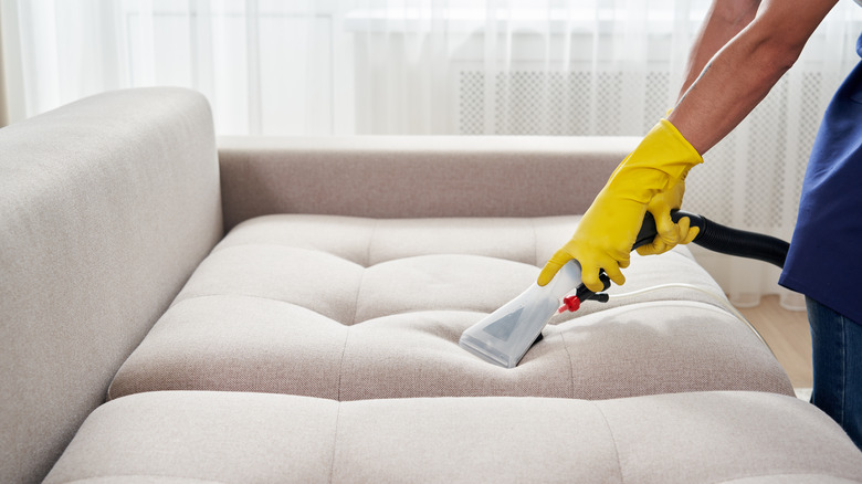 woman steam cleaning couch