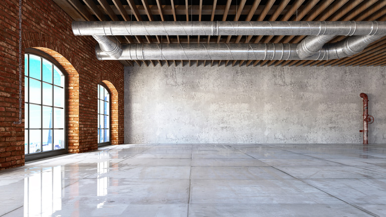 empty loft space with brick wall and concrete floor