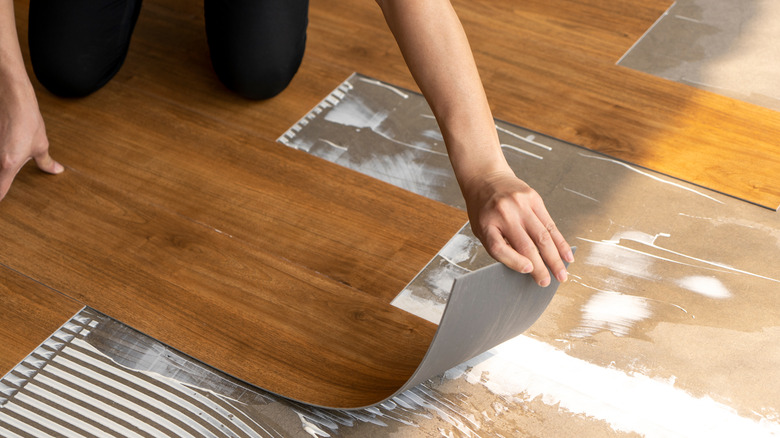 Person laying vinyl flooring