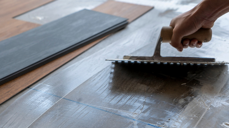 Person applying vinyl floor glue