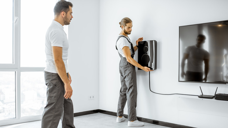 installers affixing wall speakers