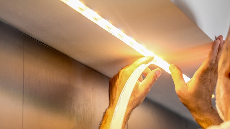 Man installing LED strip lighting