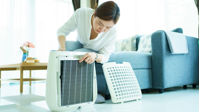 woman changing air purifier filter