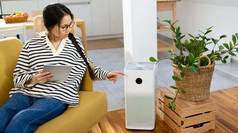 woman turning on air purifier