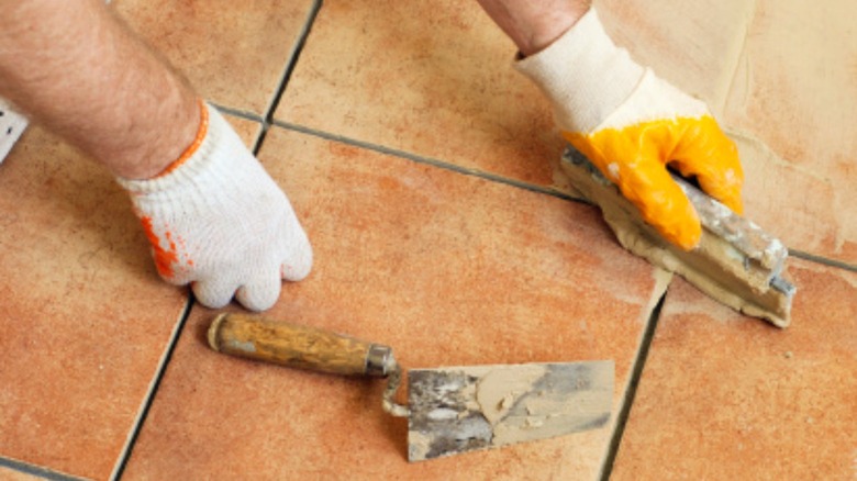 Man grouting tile flooring 