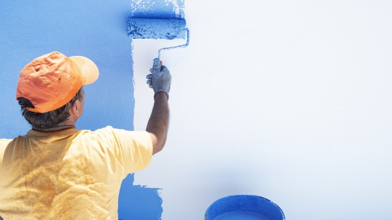 Person rolling on blue paint