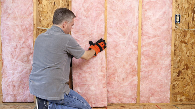 Person applying fiberglass insulation