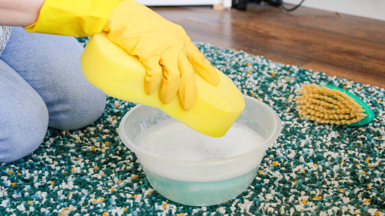 Cleaning carpet with yellow sponge