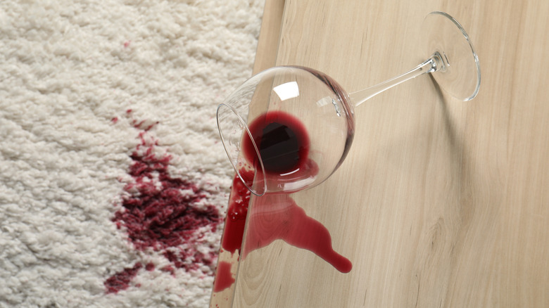 Red wine spilling from table onto carpet