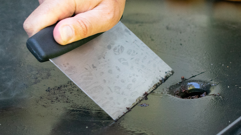 griddle scraper cleaning the surface