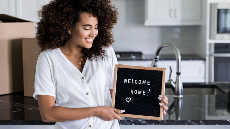 Woman holding letter board sign