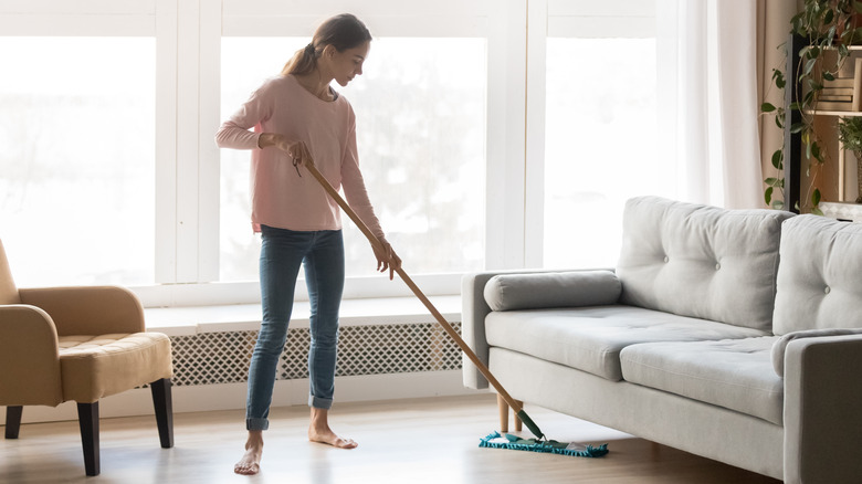 Woman dust mopping floors