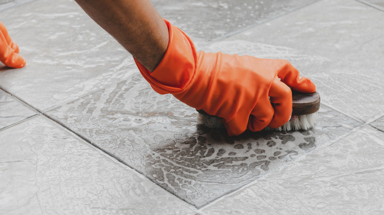 Scrubbing tile floors with brush