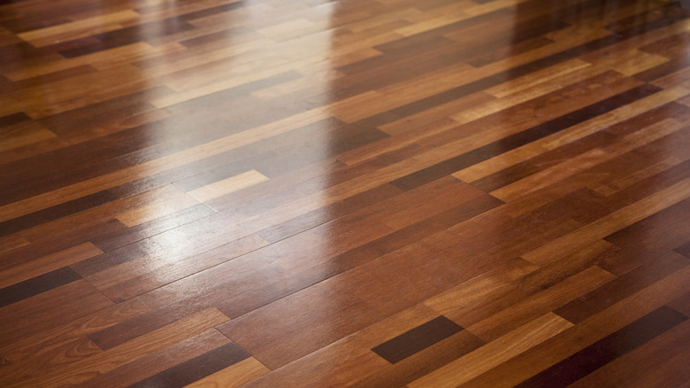 The wood floor is very shiny and reflects light.