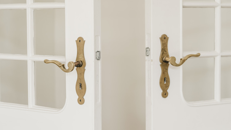 Matching brass handles on white French doors