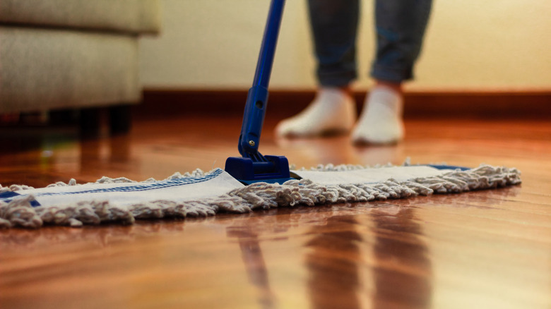 Close-up of a person cleaning hardwood floors with a mop