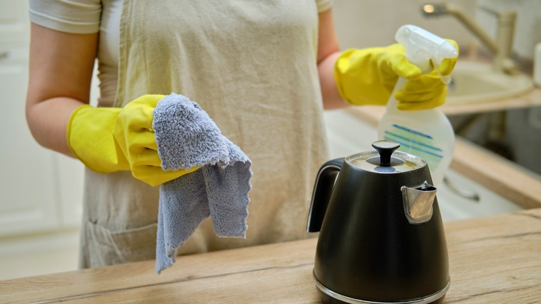 person cleaning tea kettle