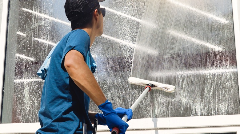 Man cleaning windows with soap