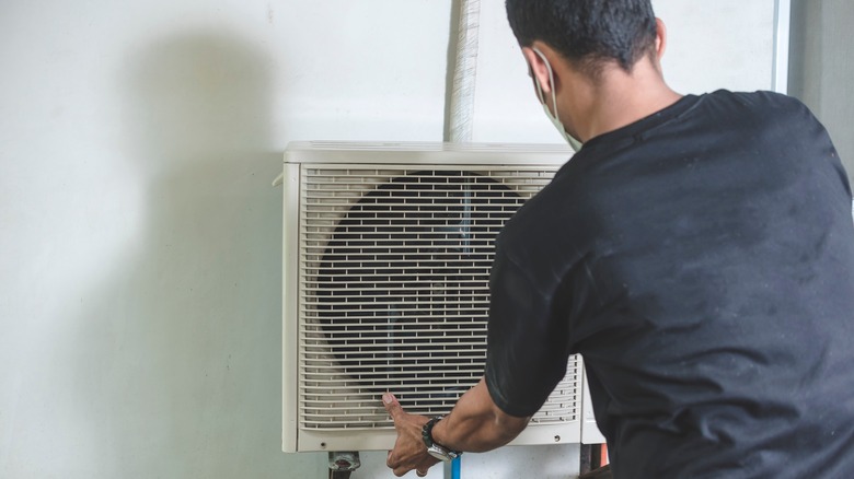 Person removing cover on AC unit