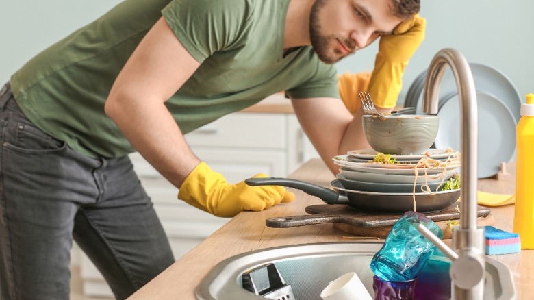 Man looking at dirty dishes