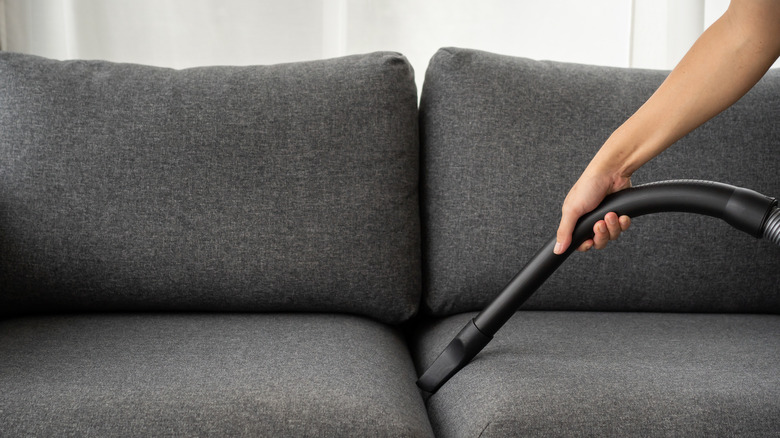 Vacuuming couch with crevice tool