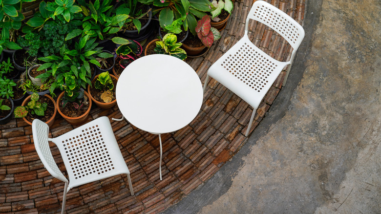 White plastic chairs and a table in a garden