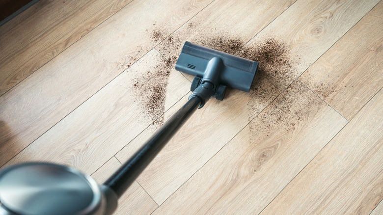 Debris is vacuumed off an unsealed hardwood floor