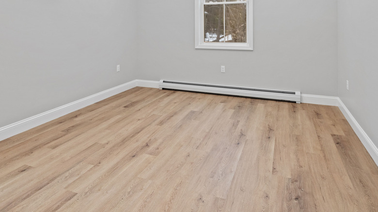 Unsealed hardwood floors are installed in an empty room