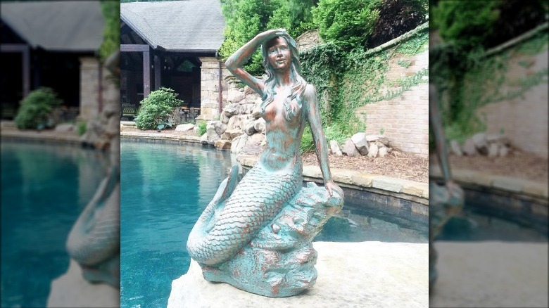 mermaid statue by a pool