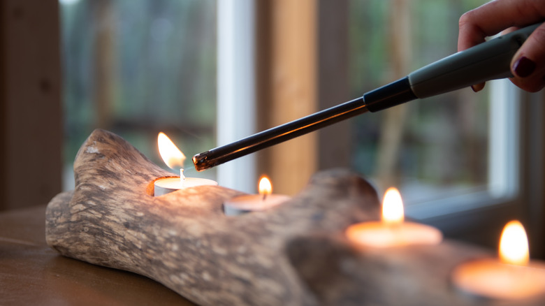 person lighting candles in log