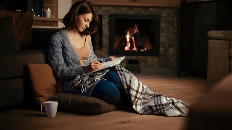 woman reading by fireplace