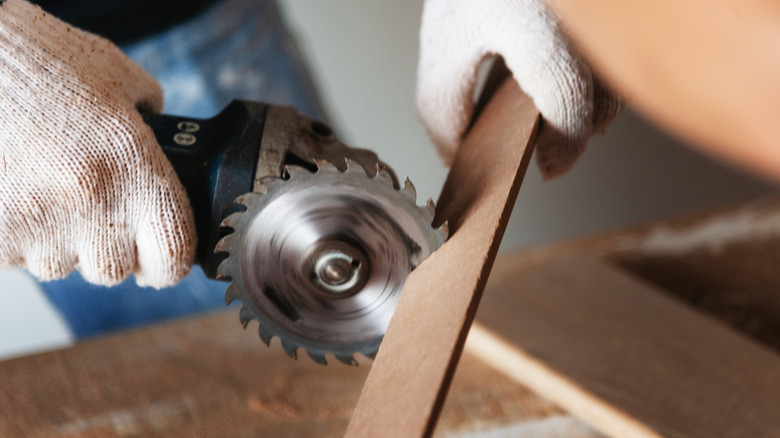 Person cutting wood with circular saw