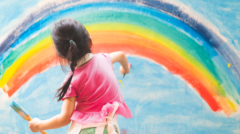 little girl painting a rainbow