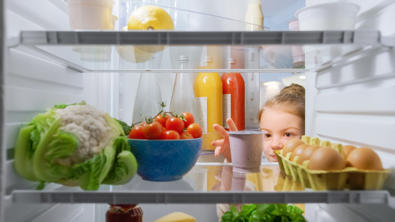 child looking in fridge 