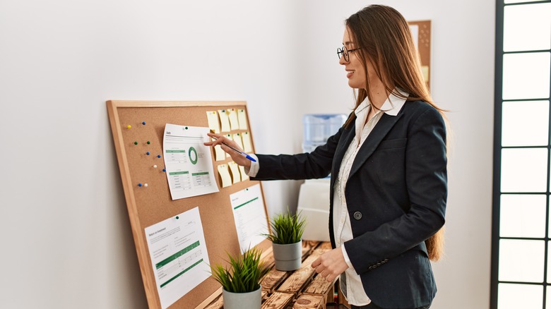 woman looking at office corkboard