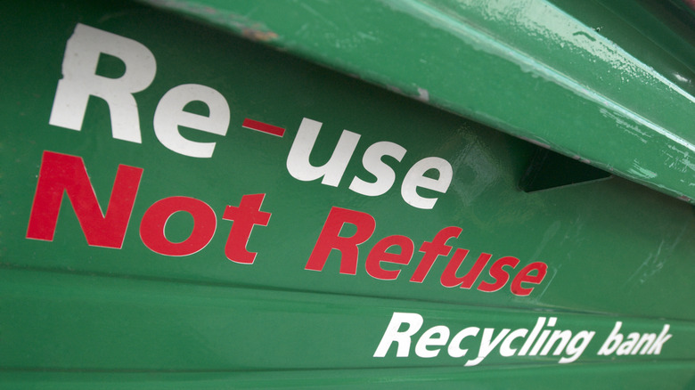 green recycling bin with red words
