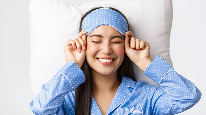 Woman wearing comfortable pajamas and sleep mask