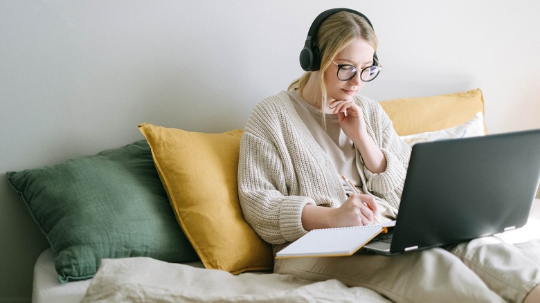 Woman working on laptop in bed 