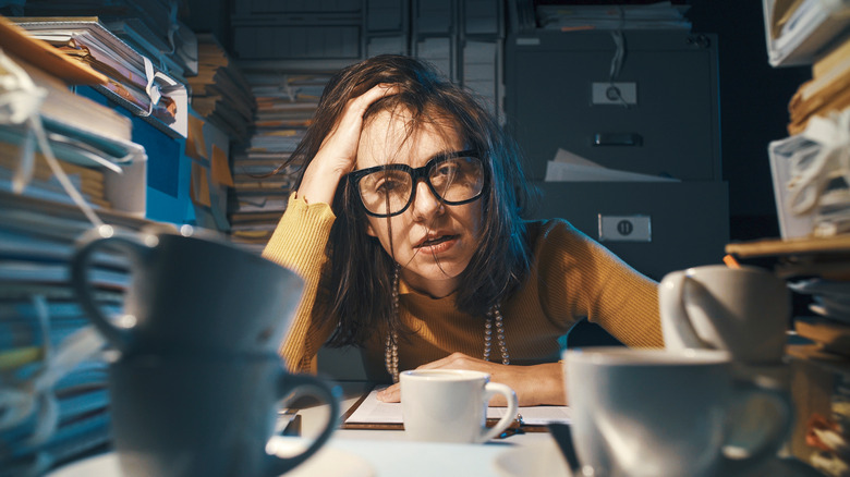 exhausted woman at disorganized desk