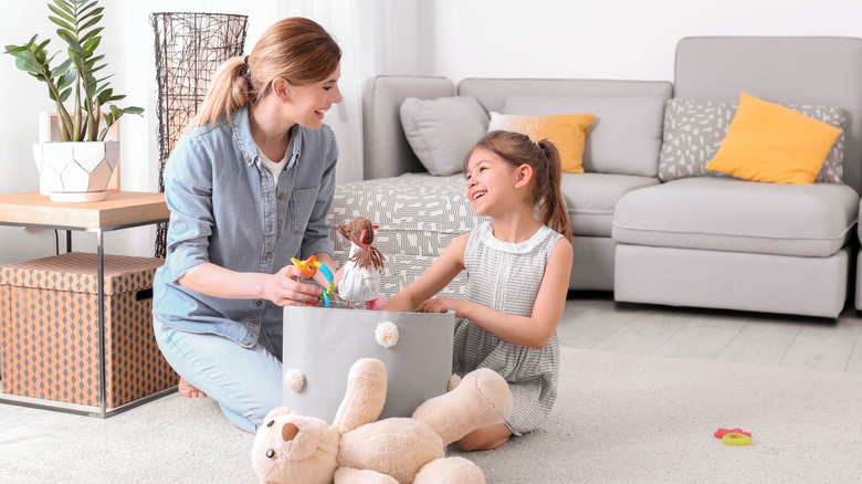 mother and daughter cleaning toys