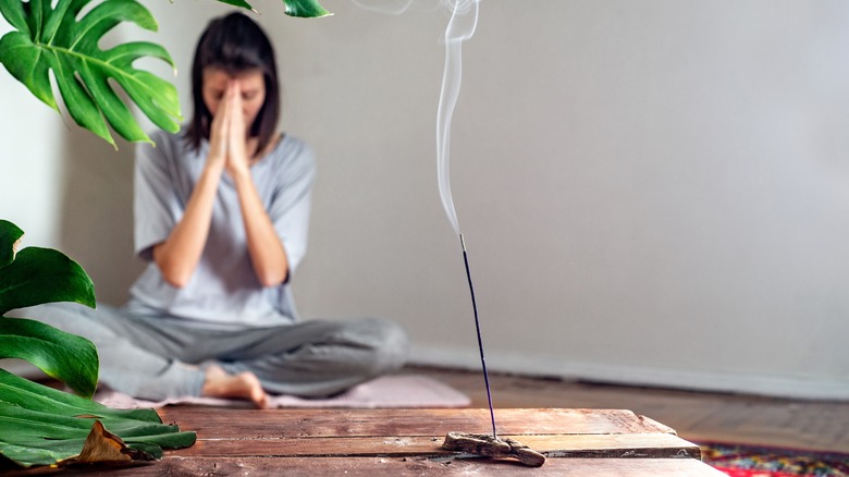 Woman meditating with incense