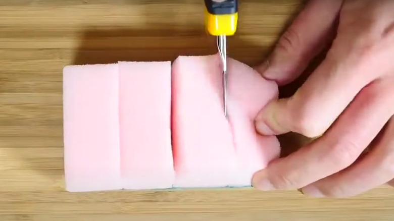 woman cutting kitchen sponge 