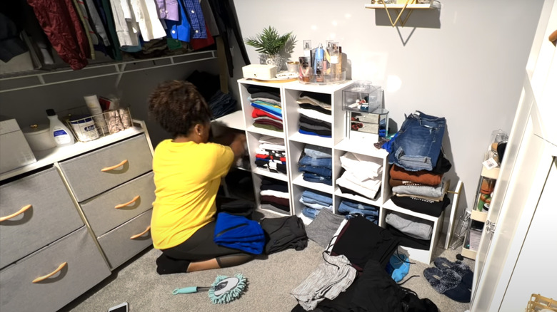 young woman cleaning closet shelves