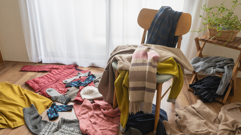 clothing heap on wooden bedroom chair and hardwood floor