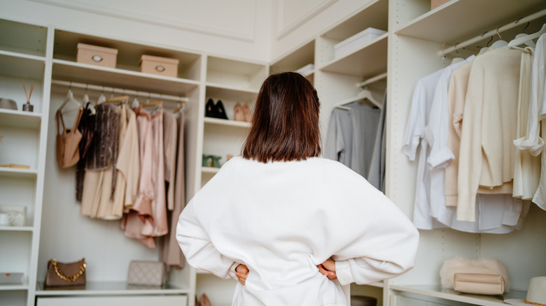 woman looking in organized walk in closet