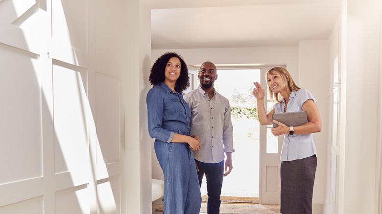 real estate agent showing couple new home