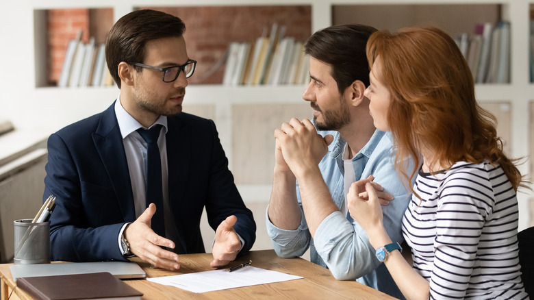 Couple speaks with businessman