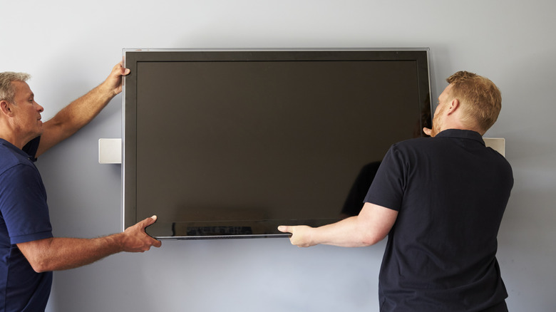 People mounting a television 